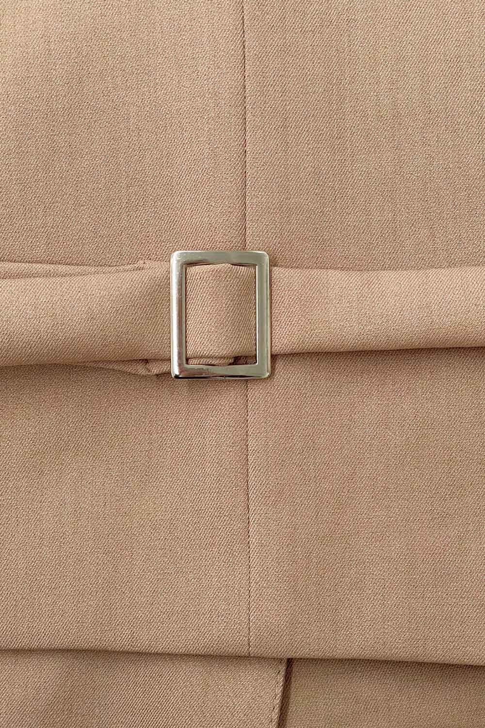 Chaleco corto de fit recto, escote v, vivos decorativos, pinzas frontales y aberturas en bajo. Detalle de trabilla ajustable posterior con hebilla y cierre frontal con hilera de botones en contraste.