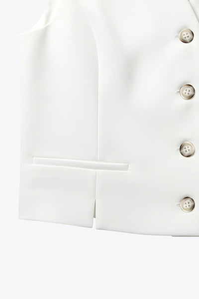 Chaleco corto de fit recto, escote v, vivos decorativos, pinzas frontales y aberturas en bajo. Detalle de trabilla ajustable posterior con hebilla y cierre frontal con hilera de botones en contraste.