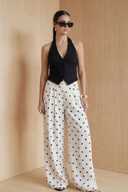 Chaleco corto cuello halter, fit ajustado, escote v, cierre frontal con hilera oculta de botones, vivos decorativos frontales y bajo v frontal. Escote en espalda y detalle de trabilla ajustable posterior.