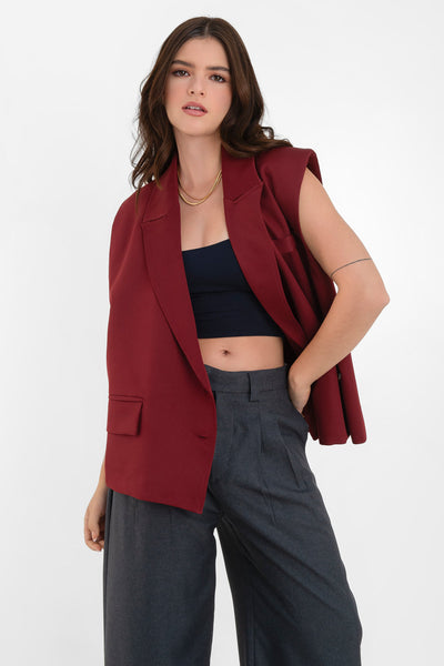 Chaleco cruzado de fit oversized, con hombreras y solapa, bolsillos delanteros con cartera y vivo decorativo frontal. Cierre con cruce de botones.
