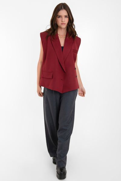 Chaleco cruzado de fit oversized, con hombreras y solapa, bolsillos delanteros con cartera y vivo decorativo frontal. Cierre con cruce de botones.