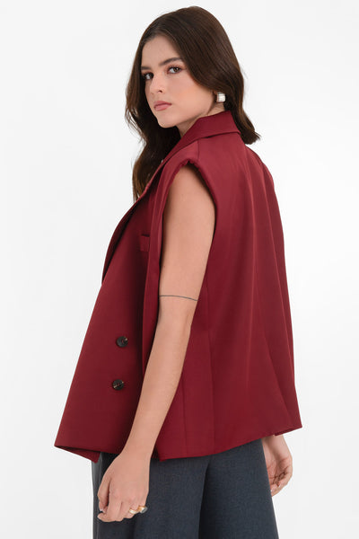 Chaleco cruzado de fit oversized, con hombreras y solapa, bolsillos delanteros con cartera y vivo decorativo frontal. Cierre con cruce de botones.