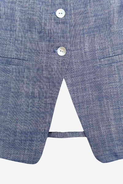 Chaleco con escote cuadrado, abotonadura frontal con botones y bolsillos tipo ojal decorativos. Con abertura discreta al frente y caída posterior en picos