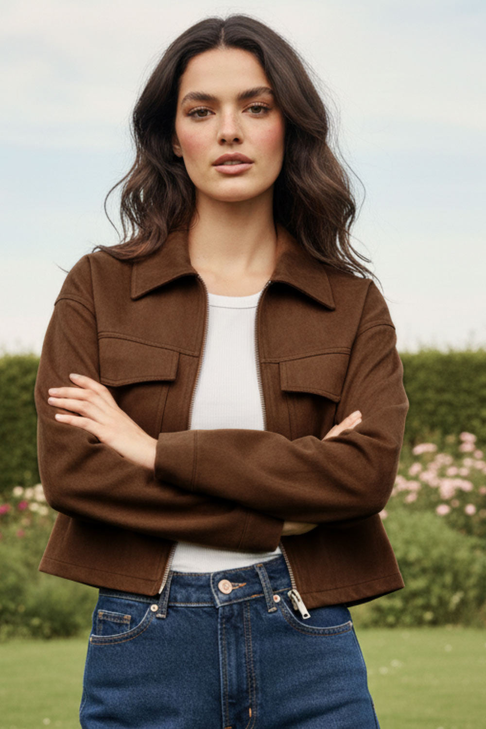 Chamarra corta de gamuza, fit recto, manga larga con puño abotonado, cuello sport, bolsillos frontales de parche con cartera y cierre frontal con cremallera visible en contraste.