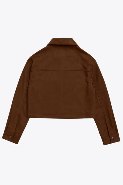 Chamarra corta de gamuza, fit recto, manga larga con puño abotonado, cuello sport, bolsillos frontales de parche con cartera y cierre frontal con cremallera visible en contraste.