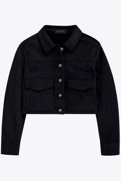 Chamarra corta fluida de gamuza, manga larga con puño abotonado, cuello camisero, bolsillos frontales de parche y cierre frontal con hilera de botones en contraste.