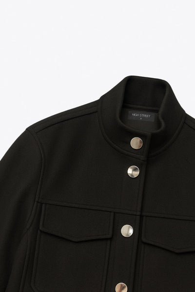 Chamarra de fit recto, manga larga con puño, cuello mock, bolsillos decorativos con cartera y vivos frontales. Cierre frontal con hilera de botones en contraste.