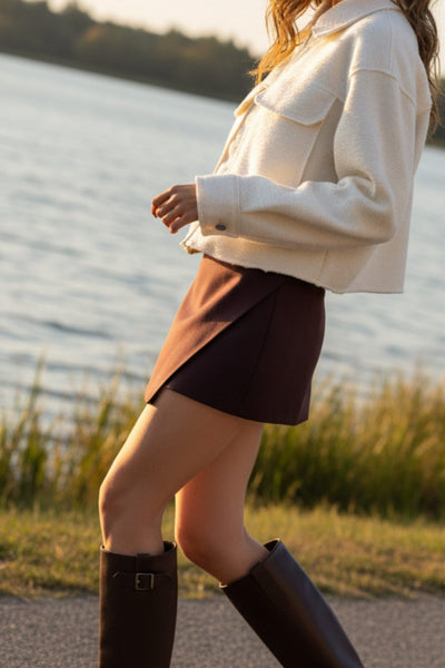 Chamarra corta de borreguillo, fit recto, manga larga con puño abotonado, cuello solapa, bolsillos frontales de parche con cartera y cierre frontal con cremallera visible en contraste.