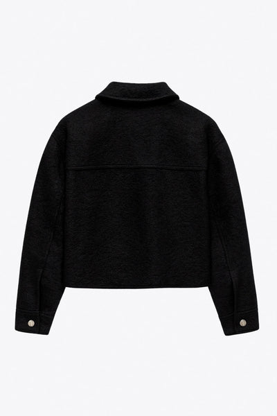 Chamarra corta de borreguillo, fit recto, manga larga con puño abotonado, cuello solapa, bolsillos frontales de parche con cartera y cierre frontal con cremallera visible en contraste.