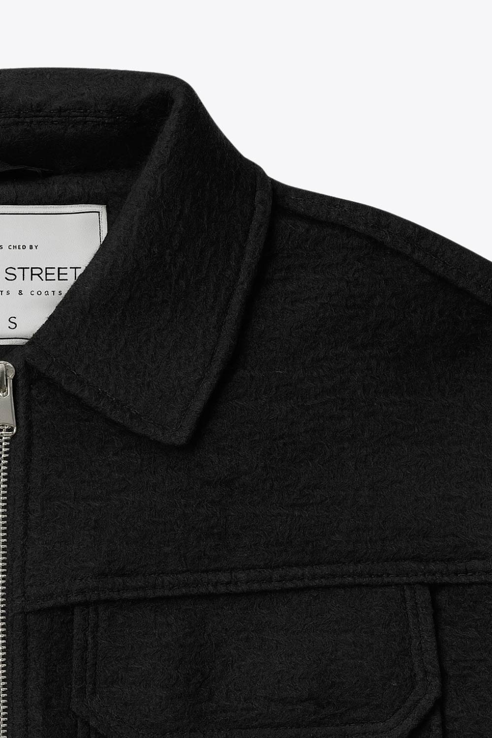 Chamarra corta de borreguillo, fit recto, manga larga con puño abotonado, cuello solapa, bolsillos frontales de parche con cartera y cierre frontal con cremallera visible en contraste.