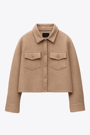 Chamarra corta de borreguillo, manga larga con puño abotonado, cuello solapa, bolsillos frontales de parche con cartera y botón. Cierre frontal con hilera de botones.