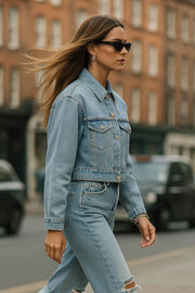 Chamarra corta de denim, fit ligeramente oversized, manga larga con puño abotonado, cuello clásico, bolsillos frontales con cartera y botón en contraste. Cierre frontal con hilera de botones en contraste.