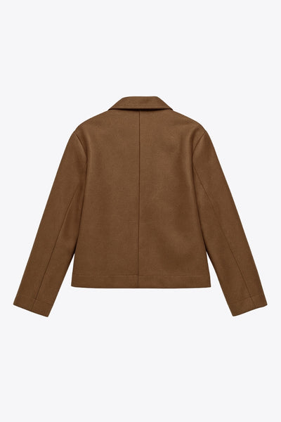 Chamarra corta de fit recto, manga larga con puño abotonado, cuello solapa, bolsillos delanteros con vivos y cierre frontal con hilera de botones en contraste.