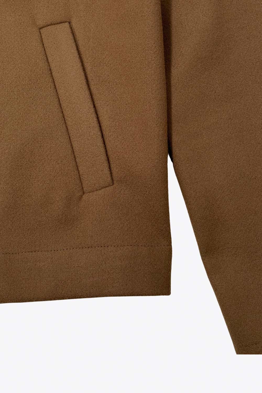 Chamarra corta de fit recto, manga larga con puño abotonado, cuello solapa, bolsillos delanteros con vivos y cierre frontal con hilera de botones en contraste.