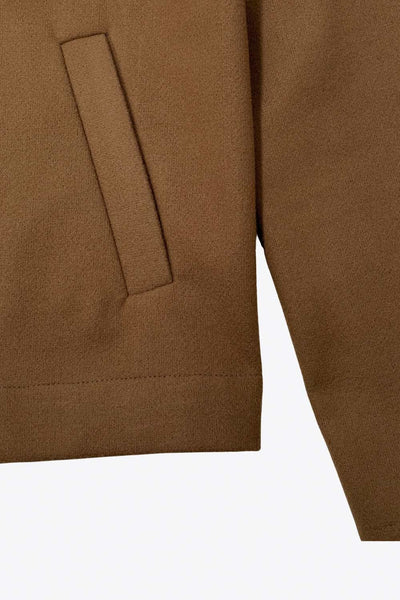 Chamarra corta de fit recto, manga larga con puño abotonado, cuello solapa, bolsillos delanteros con vivos y cierre frontal con hilera de botones en contraste.