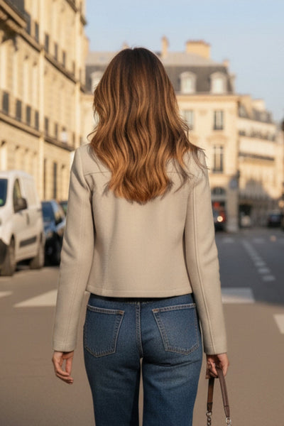 Chamarra corta de fit recto, cuello camisero, manga larga con puño abotonado, cortes decorativos frontales, bolsillos delanteros con cartera y botón. Cierre frontal con hilera de botones en contraste.