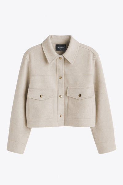 Chamarra corta de fit recto, cuello camisero, manga larga con puño abotonado, cortes decorativos frontales, bolsillos delanteros con cartera y botón. Cierre frontal con hilera de botones en contraste.