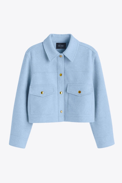 Chamarra corta de fit recto, cuello camisero, manga larga con puño abotonado, cortes decorativos frontales, bolsillos delanteros con cartera y botón. Cierre frontal con hilera de botones en contraste.