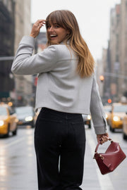 Chamarra corta de fit recto, cuello camisero, manga larga con puño abotonado, cortes decorativos frontales, bolsillos delanteros con cartera y botón. Cierre frontal con hilera de botones en contraste.