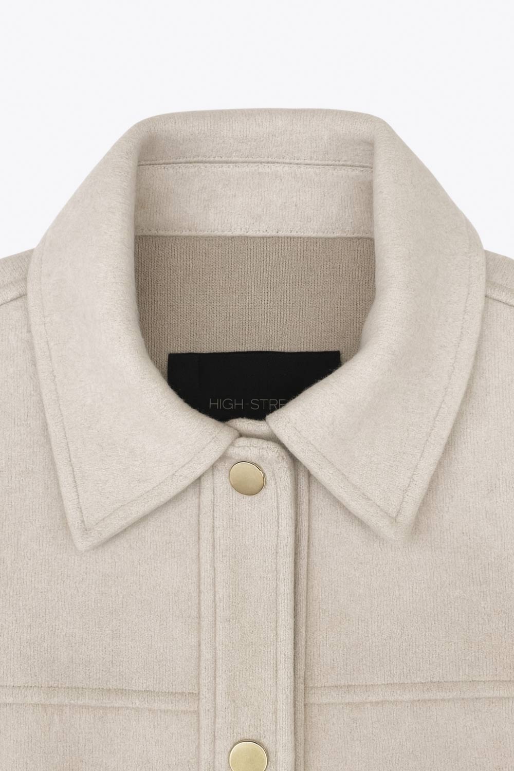 Chamarra corta de fit recto, cuello camisero, manga larga con puño abotonado, cortes decorativos frontales, bolsillos delanteros con cartera y botón. Cierre frontal con hilera de botones en contraste.