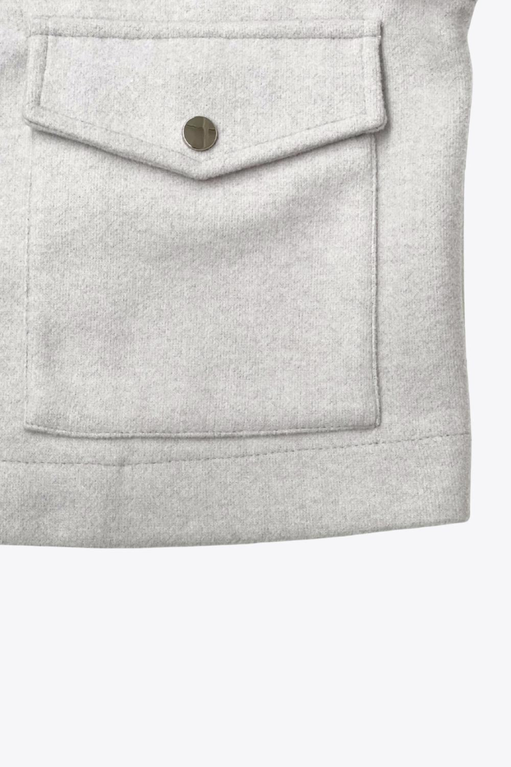 Chamarra corta de fit recto, cuello camisero, manga larga con puño abotonado, cortes decorativos frontales, bolsillos delanteros con cartera y botón. Cierre frontal con hilera de botones en contraste.