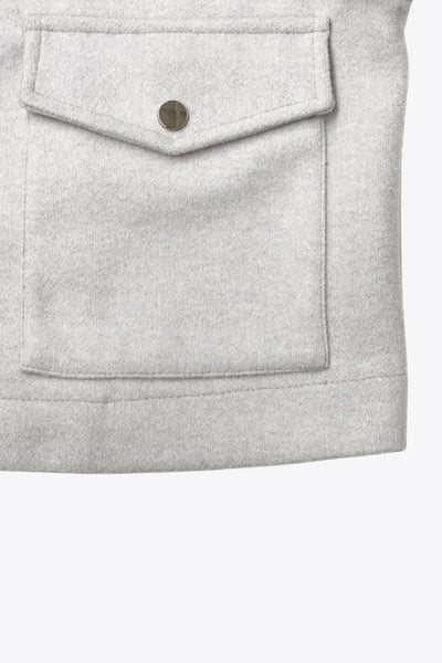 Chamarra corta de fit recto, cuello camisero, manga larga con puño abotonado, cortes decorativos frontales, bolsillos delanteros con cartera y botón. Cierre frontal con hilera de botones en contraste.