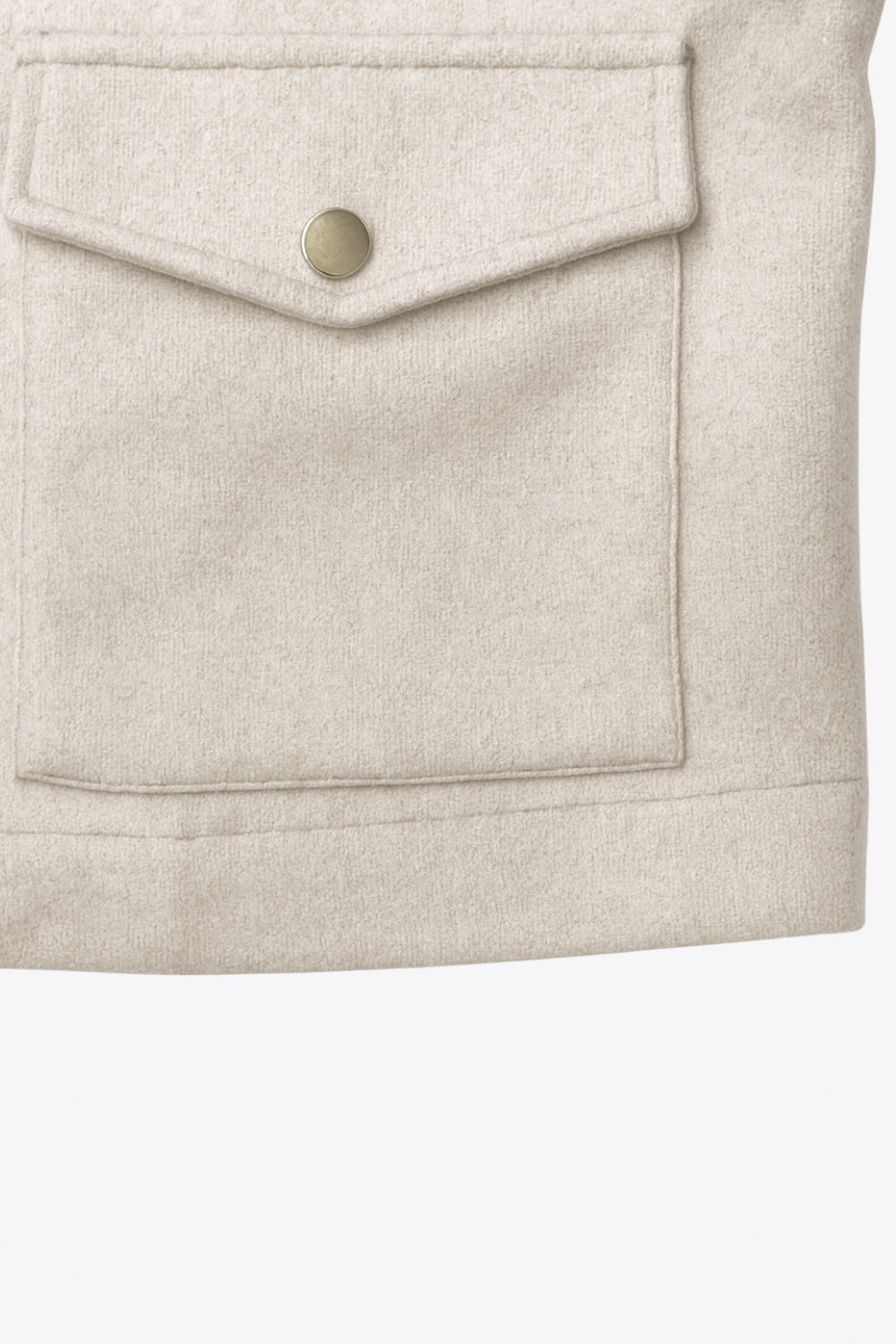 Chamarra corta de fit recto, cuello camisero, manga larga con puño abotonado, cortes decorativos frontales, bolsillos delanteros con cartera y botón. Cierre frontal con hilera de botones en contraste.