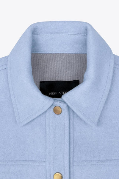 Chamarra corta de fit recto, cuello camisero, manga larga con puño abotonado, cortes decorativos frontales, bolsillos delanteros con cartera y botón. Cierre frontal con hilera de botones en contraste.