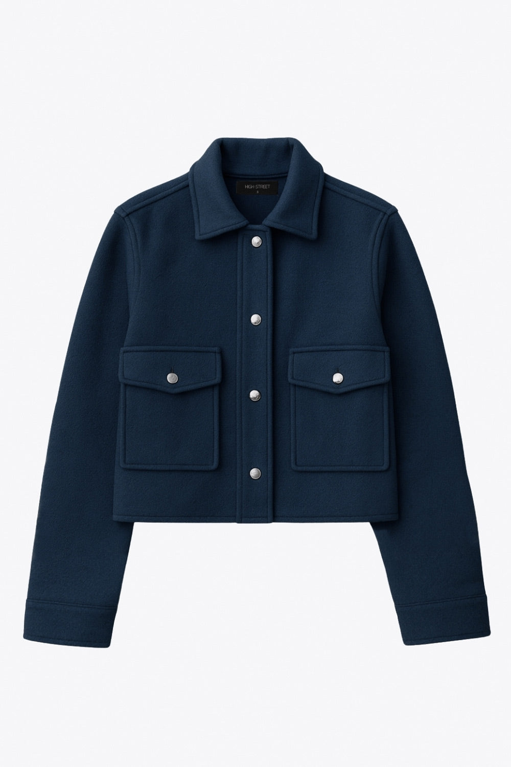 Chamarra corta de fit recto, cuello camisero, manga larga con puño abotonado, bolsillos delanteros con cartera y botón. Cierre frontal con hilera de botones en contraste.