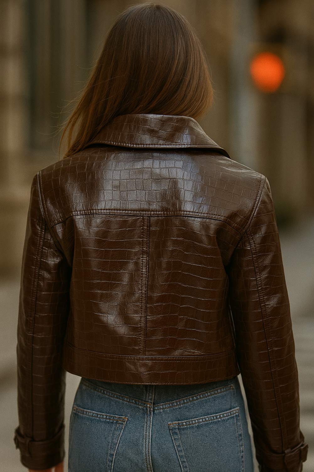 Chamarra corta de efecto piel, textura animal, cuello solapa, bolsillos delanteros decorativos con cartera, fit recto, manga larga con trabilla y botón en puños. Cierre frontal con hilera de botones y detalle de pretina en cintura.