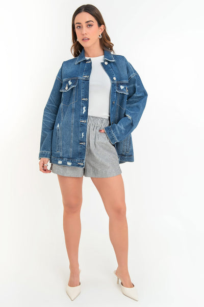 Chamarra de denim, fit oversized, manga larga con puño abotonado, cuello clásico, bolsillos delanteros, frontales con cartera y botón en contraste. Cierre frontal con hilera de botones en contraste. Detalle de trabilllas en pretina y rotos.