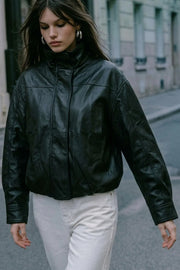 Chamarra de efecto piel, fit oversized, manga larga con puño abotonado, cuello alto, bolsillos delanteros con vivos, cortes decorativos y elástico en bajo. Cierre frontal con cremallera oculta.