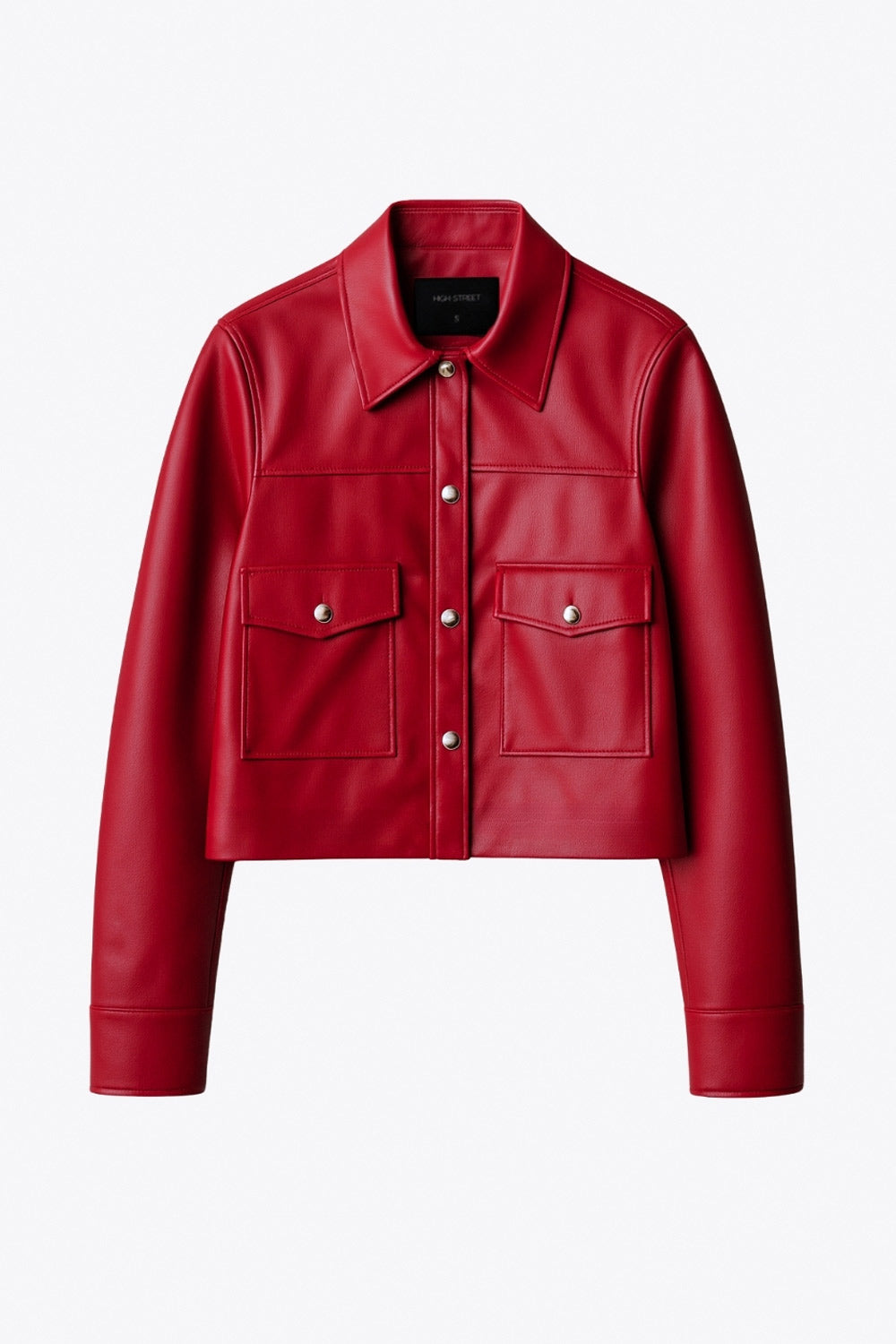 Chamarra corta de efecto piel, fit recto, cuello camisero, manga larga con puño abotonado, bolsillos delanteros de parche con botones y cierre frontal con botones de presión en contraste.