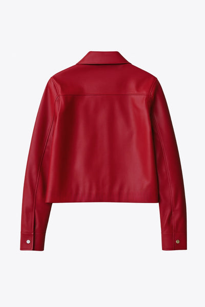 Chamarra corta de efecto piel, fit recto, cuello camisero, manga larga con puño abotonado, bolsillos delanteros de parche con botones y cierre frontal con botones de presión en contraste.