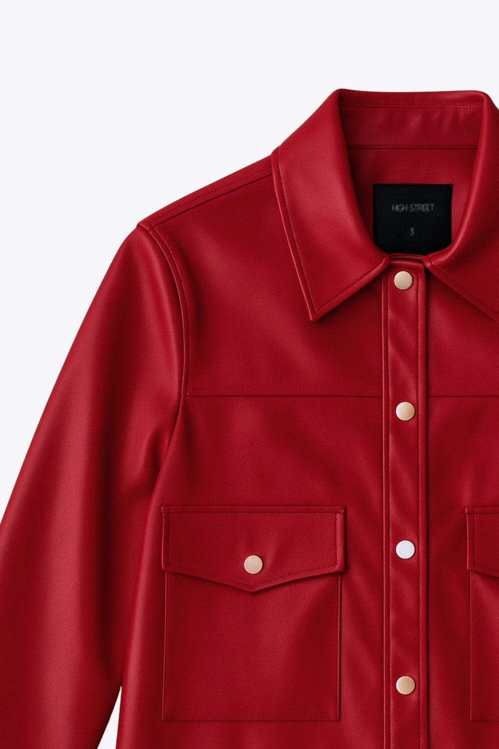 Chamarra corta de efecto piel, fit recto, cuello camisero, manga larga con puño abotonado, bolsillos delanteros de parche con botones y cierre frontal con botones de presión en contraste.