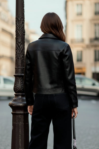 Chamarra corta de efecto piel, fit recto, cuello camisero, manga larga con puño abotonado, bolsillos delanteros de parche con cartera y botón. Cierre frontal con hilera de botones.