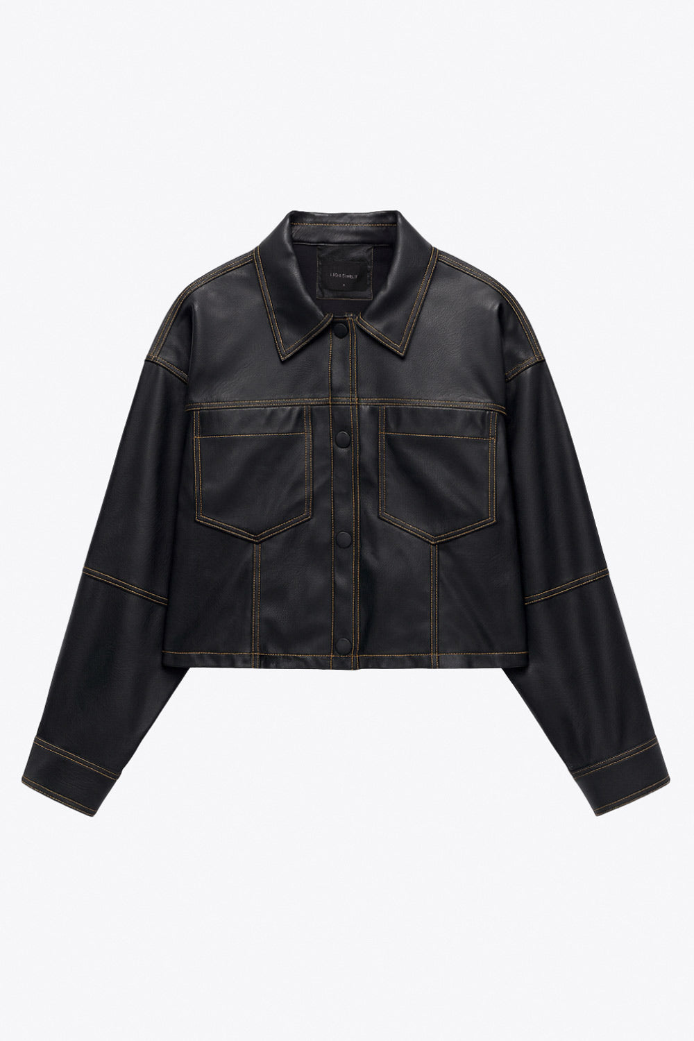 Chamarra corta de efecto piel, fit recto, cuello camisero, manga larga con puño abotonado, bolsillos delanteros de parche y cierre frontal con hilera de botones de presión. Detalle de costuras decorativas en contraste.
