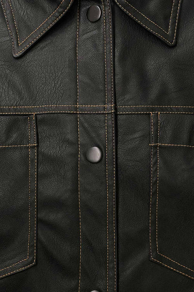Chamarra corta de efecto piel, fit recto, cuello camisero, manga larga con puño abotonado, bolsillos delanteros de parche y cierre frontal con hilera de botones de presión. Detalle de costuras decorativas en contraste.