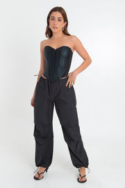 Corset de efecto piel, escote corazón, fit ajustado, costuras frontales con varillas y bajo curveado frontal. Cierre frontal con broches.