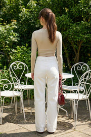 Crop top de escote v cruzado con plisados frontales, manga larga y fit ajustado.