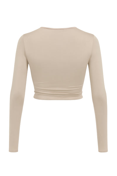 Crop top de escote v cruzado con plisados frontales, manga larga y fit ajustado.