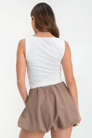 Falda corta globo de cintura alta elástica, pliegues en cintura y bajo con acabado en volumen.