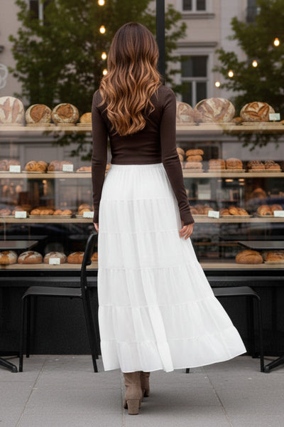 Falda maxi de cintura media con pretina elástica, corte en a y capas de olanes en bajo.