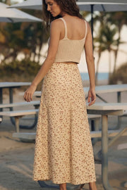Falda midi de estampado floral, cintura alta con pretina, corte en a, aberturas frontales en bajo, botones decorativos frontales y cierre posterior con cremallera oculta.