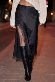 Falda midi satinada de corte en a, cintura alta, bajo asimétrico con encaje en borde y abertura frontal. Cierre lateral con cremallera oculta.