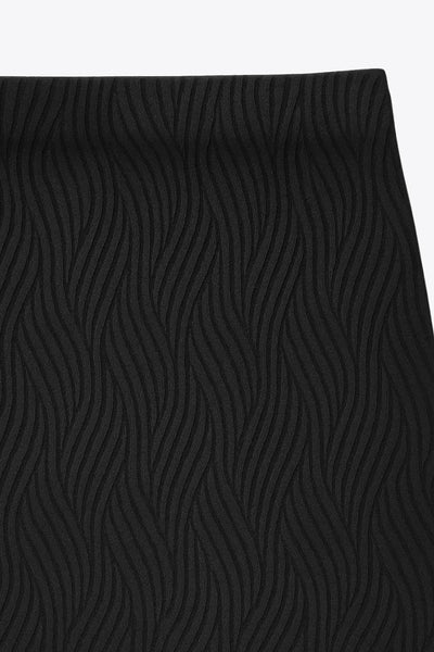 Falda midi de fit ajustado, cintura media elástica, abertura lateral en bajo y detalle de textura en tejido.