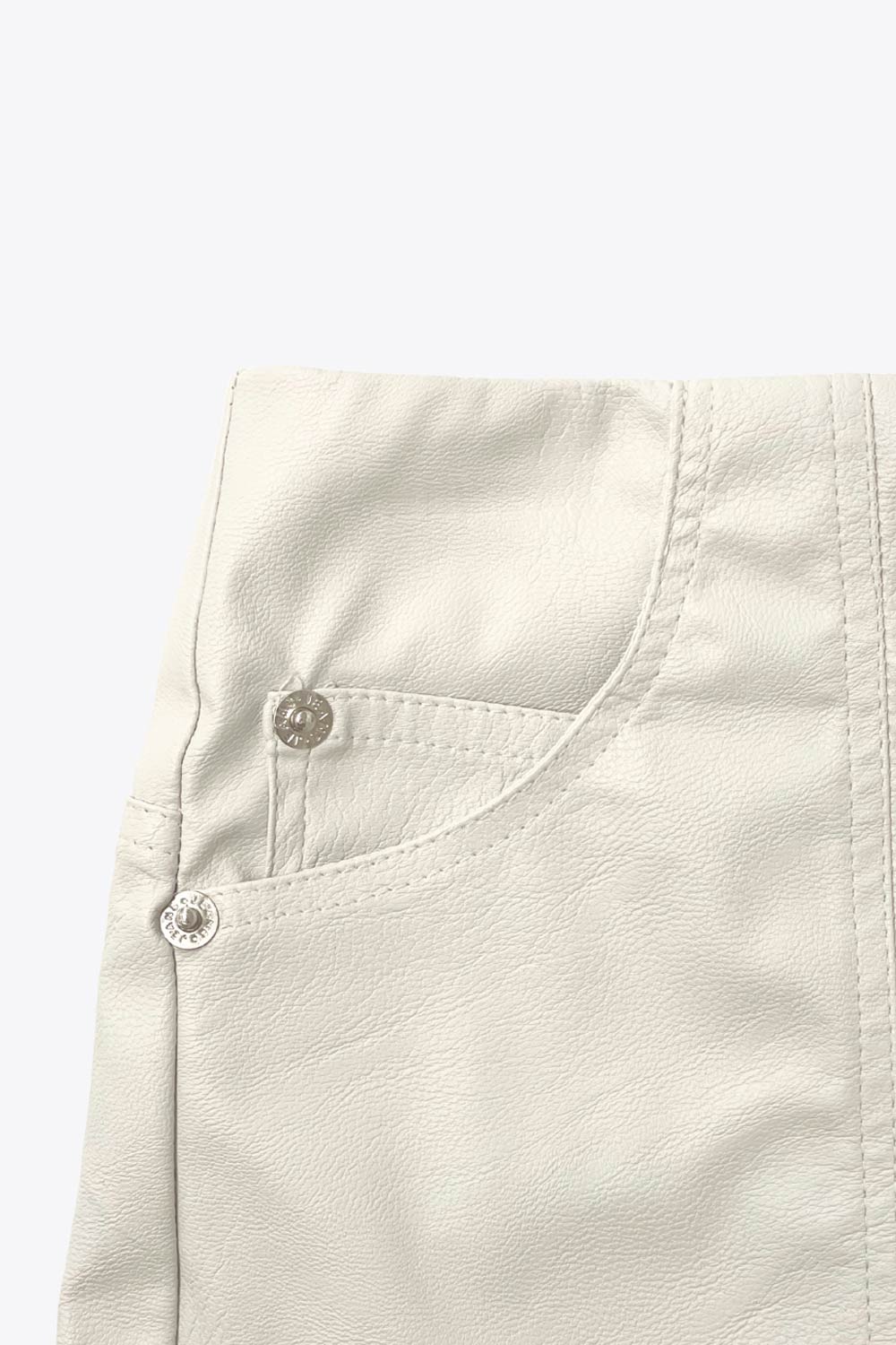 Falda corta de efecto piel, fit ajustado, cintura alta, costuras frontales decorativas, bolsillos delanteros y traseros de parche. Cierre frontal con cremallera oculta.