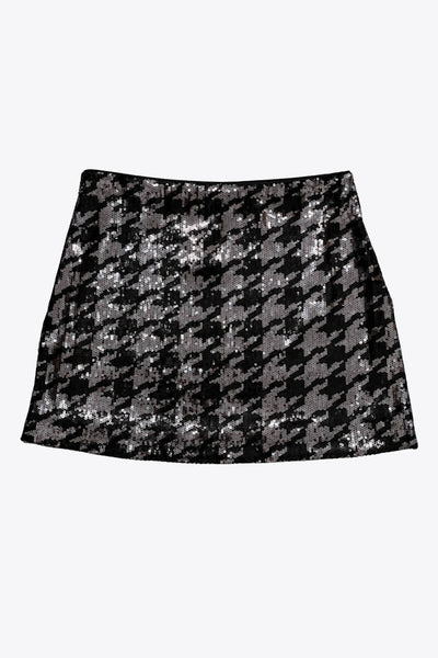 Falda corta de lentejuelas, estampado pata de gallo, fit ajustado, cintura alta y cierre lateral con cremallera oculta.