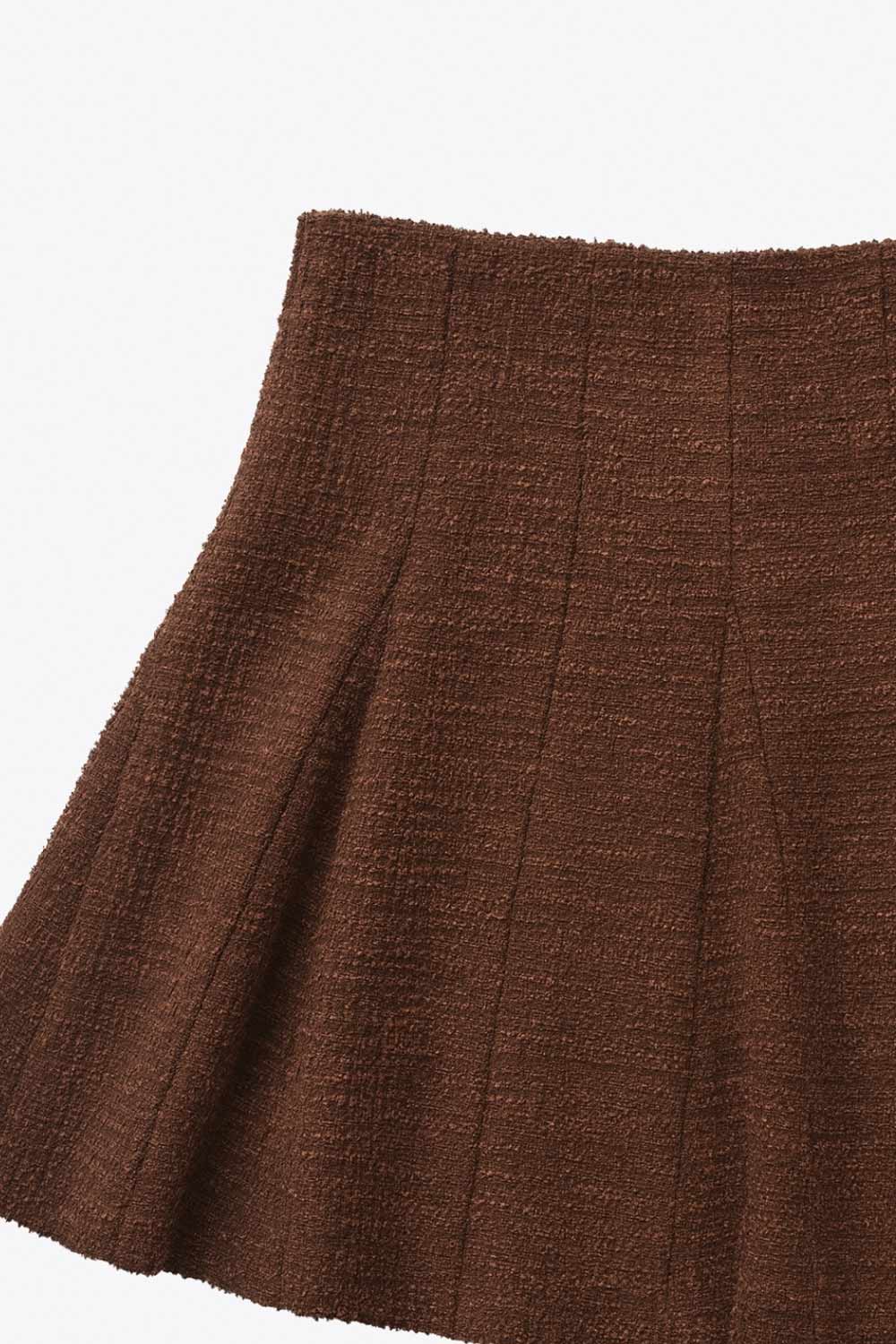 Falda short corto de bouclé, cintura alta, corte en a y olanes en bajo.