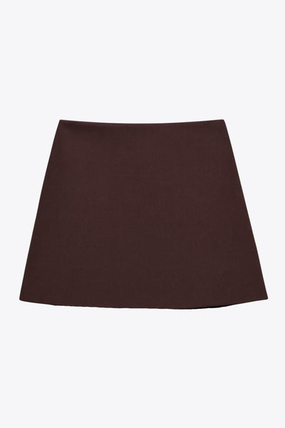 Mini short tipo falda ajustado confeccionado en tejido blanco estructurado. Con bolsillos traseros simulados.